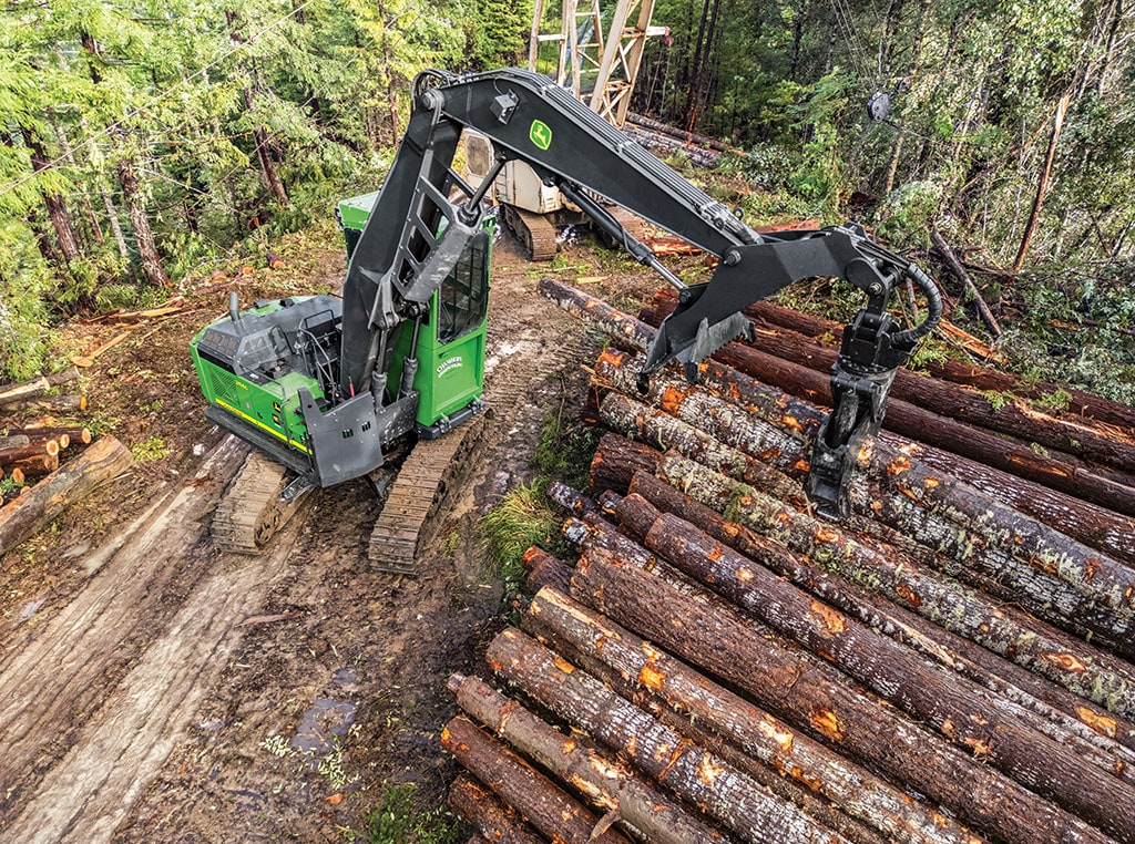 A John Deere 948L-II Grapple Skidder rolls down the ridge, clutching freshly cut tree trunks.