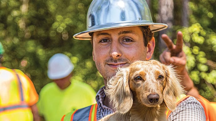 Josh Lewis holding pet dachshund