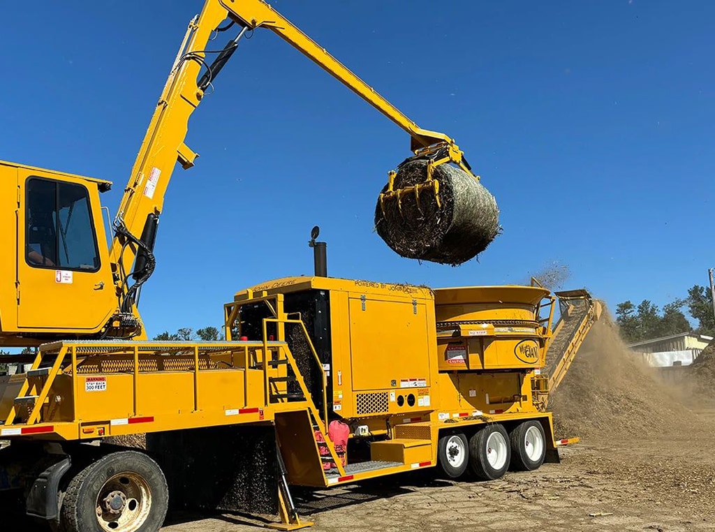 A Mighty Giant hay grinder powered by a John Deere JD18 industrial engine processing bales of hay