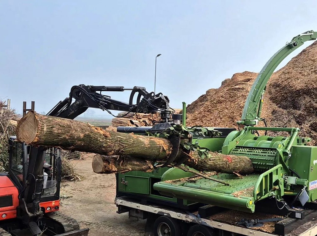 Pezzalato’s PTH 1200 drum wood chipper powered by a JD14 industrial engine chipping a small log into a large pile of wood chips