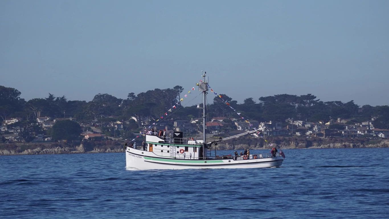 Side view of the Western Flyer fishing vessel cruising at sea repowered by a John Deere marine engine.