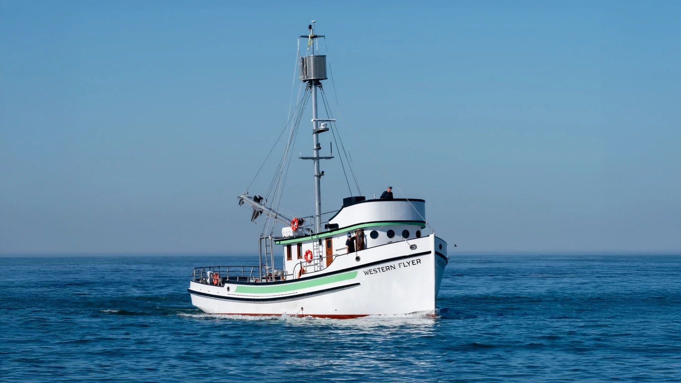 The Western Flyer vessel on the water, powered by a John Deere marine engine.