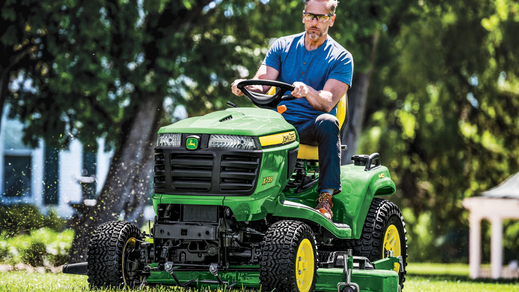 Man cutting grass on a John Deere X739 Lawn Tractor.