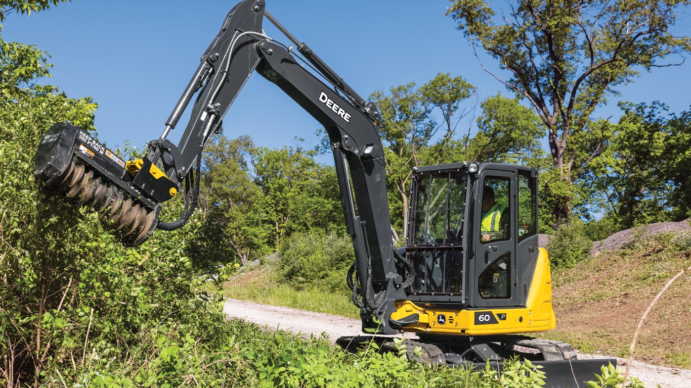 60 P-Tier compact excavator using a mulching head attachment to clear trees and hedges