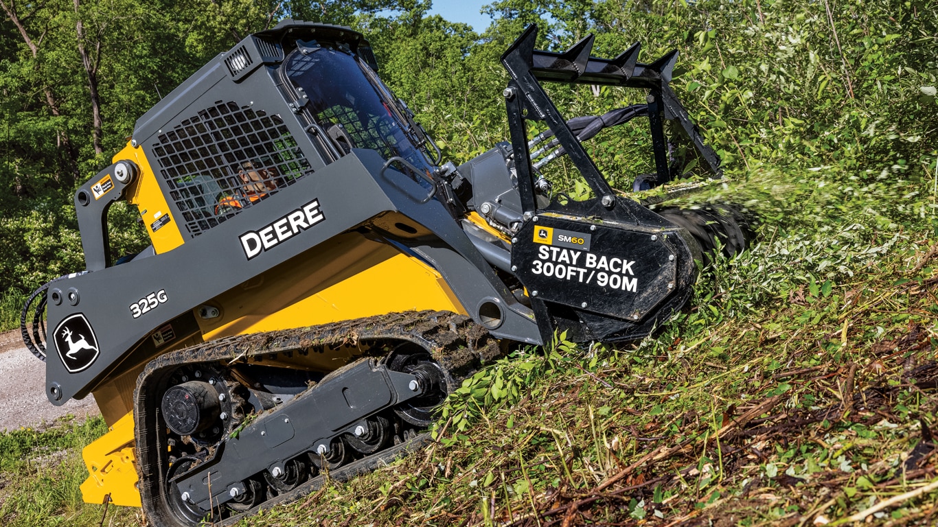 325G compact track loader using a SM60 mulching head attachment to cut brush