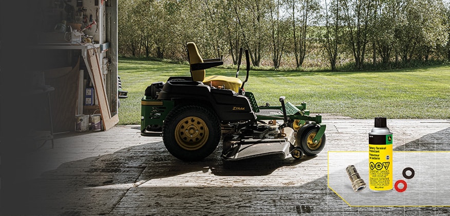 Riding lawn mower parked in a garage with a John Deere battery terminal protector kit shown in the lower right.