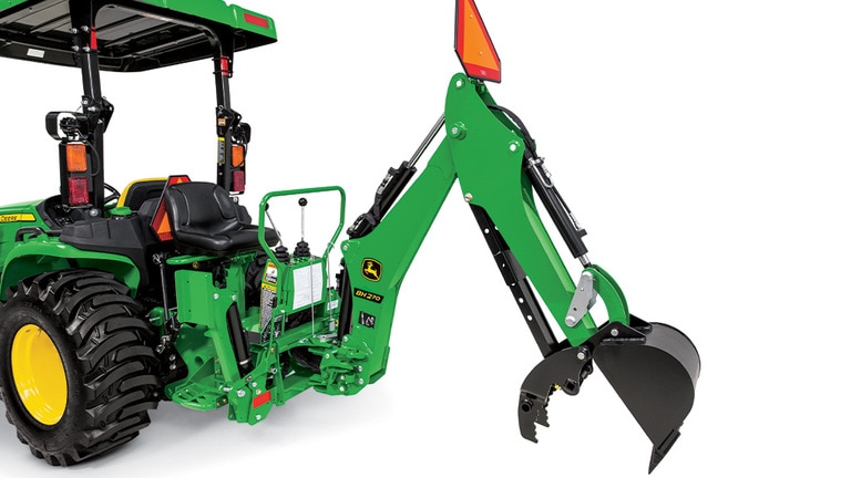 A studio close-up of a green backhoe attached to a Deere compact tractor with the bucket claw open. (7th thumbnail)