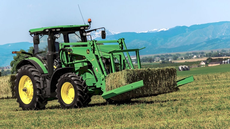 field image of Frontier™ AB17K Large square bale squeeze attached to a tractor