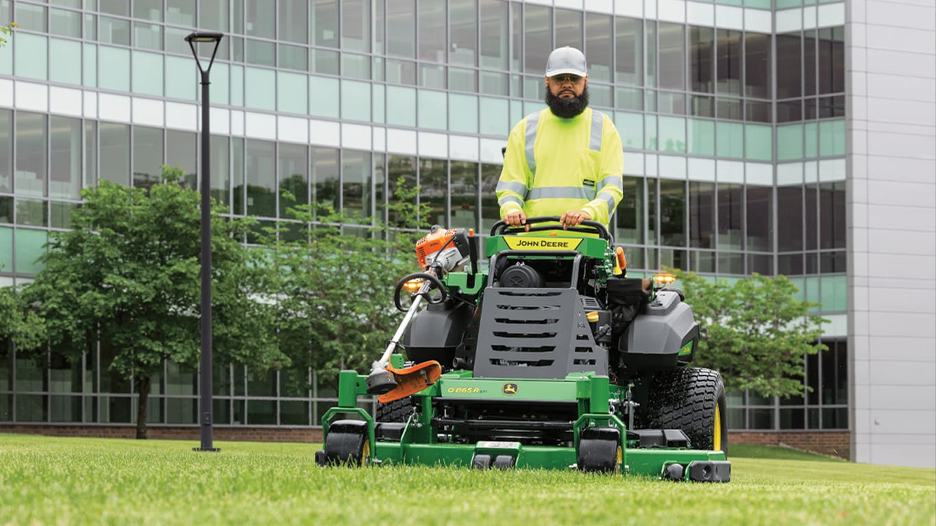 man driving a QuikTrak mower with a 60 in FastBack PRO deck