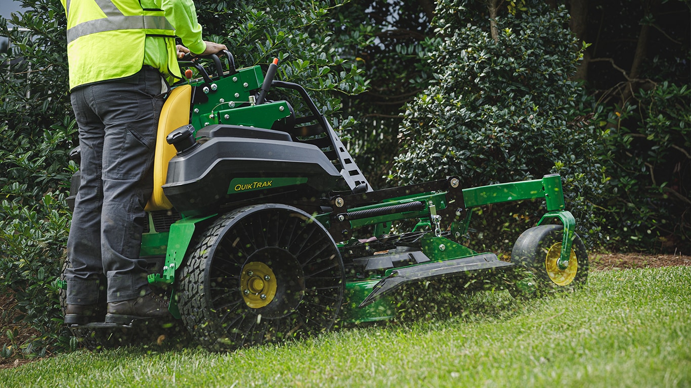 man driving a QuikTrak mower with TWEEL airless tires