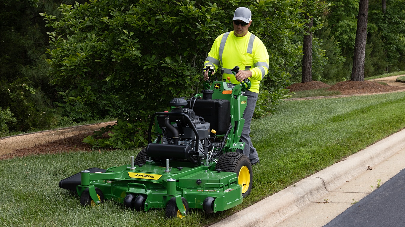 man mowing with a walk-behind mower