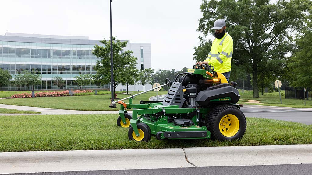 Worker using the Q800 Series QuikTrack stand-on mower