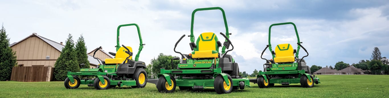 Three zero-turn mowers on a lawn