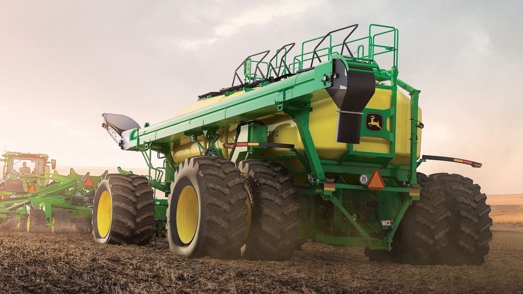 Rear view of tractor with C110T air cart in the field seeding Rear view of tractor with C110T air cart in the field seeding