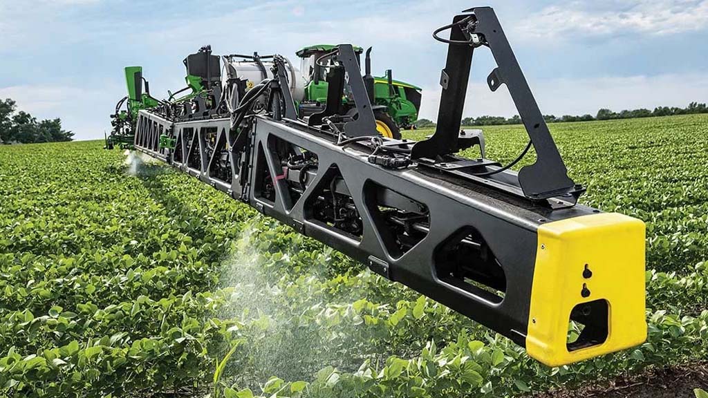 Increased Yields Photograph shot from a 3/4 angle showing a See & SprayTM-equipped John Deere Sprayer making an application pass in row crops.