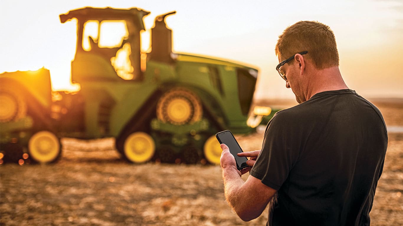 Farmer controlling an autonomous 9RX Tractor with a mobile phone