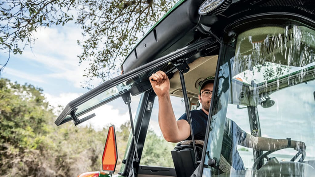 man opening 5e series tractor premium cab window