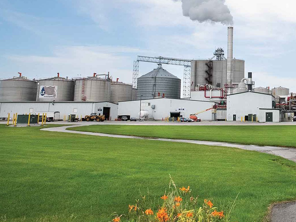 an ethanol processing facility including various white buildings and grey silos