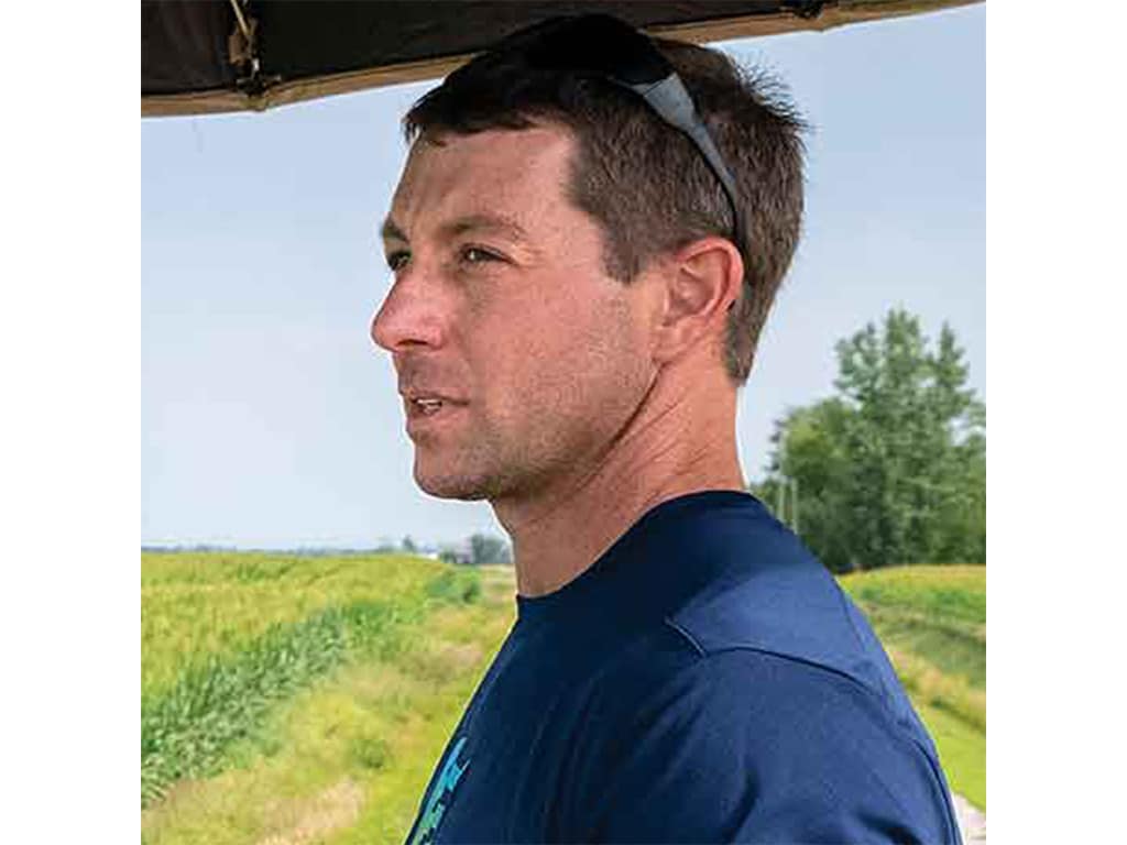 a closeup profile of a farmer with sunglasses atop their head