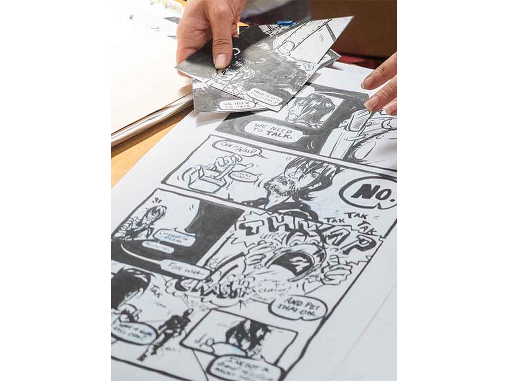 closeup of a black and white comic book draft on a desk