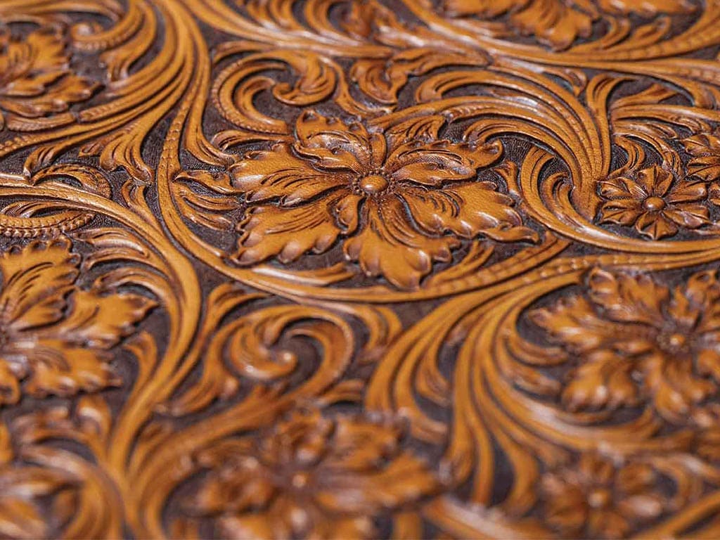 Closeup of intricately carved brown leather in floral pattern