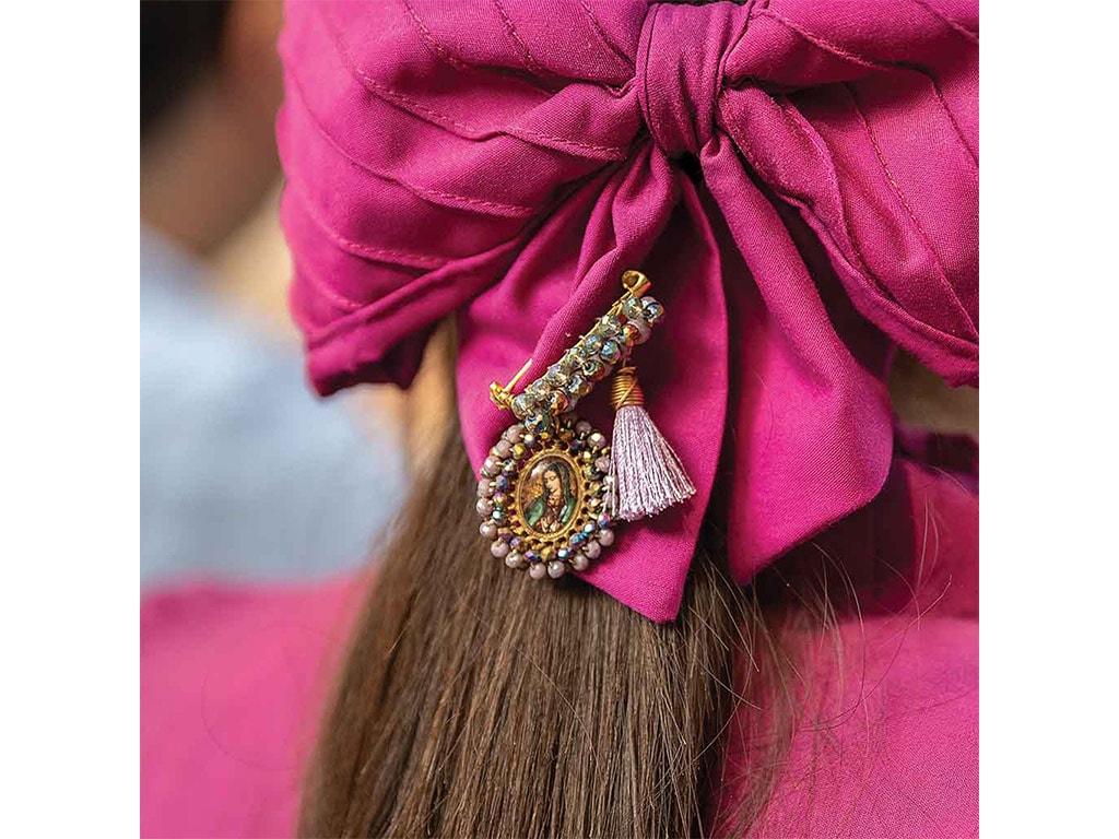 closeup of an escaramuza rider's hair bow with an intricate good luck pin attached