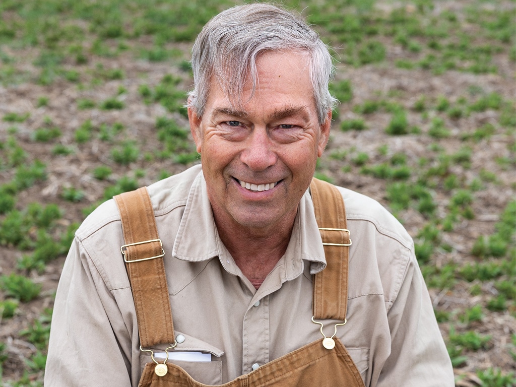 person in a field wearing brown overalls