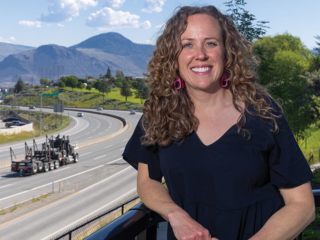 person on a balcony with a road in the background