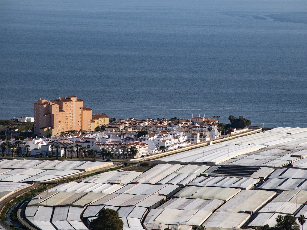 aerial view of a sprawl of greenhouses at the coast