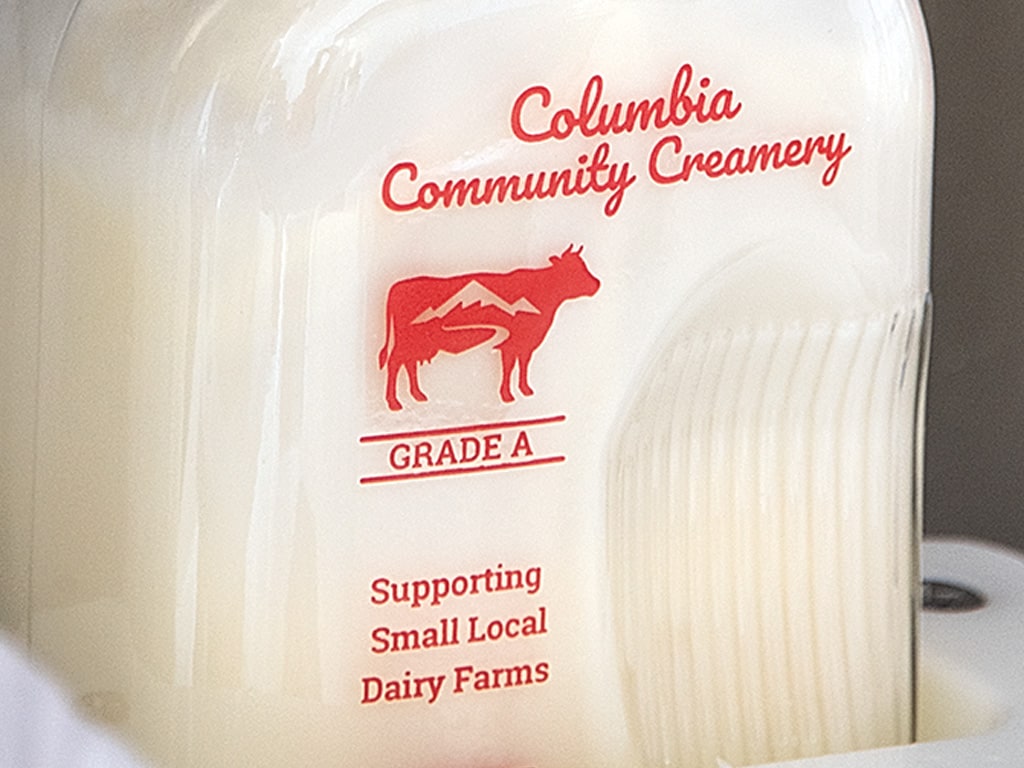 close up view of a full Columbia Community Creamery grade A milk bottle