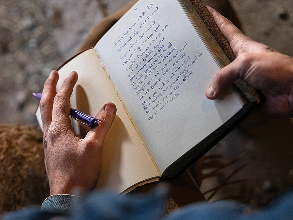 a pair of hands holding a handwritten journal