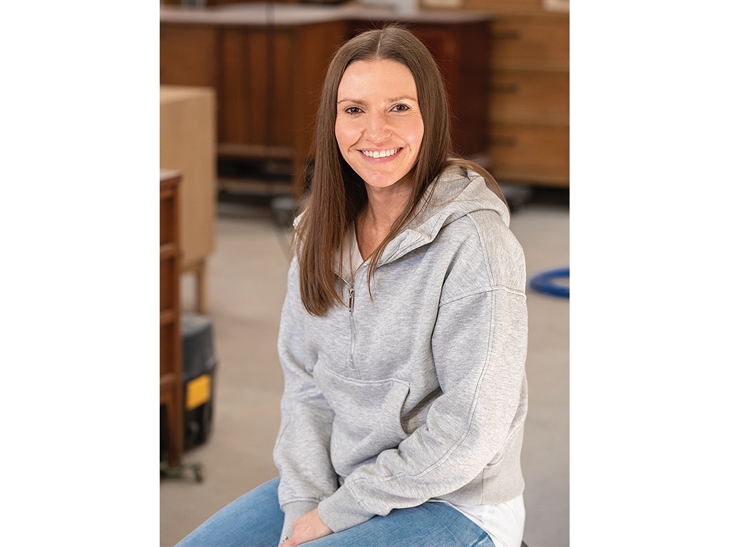 sitting woman smiling wearing grey hoody and blue jeans pant