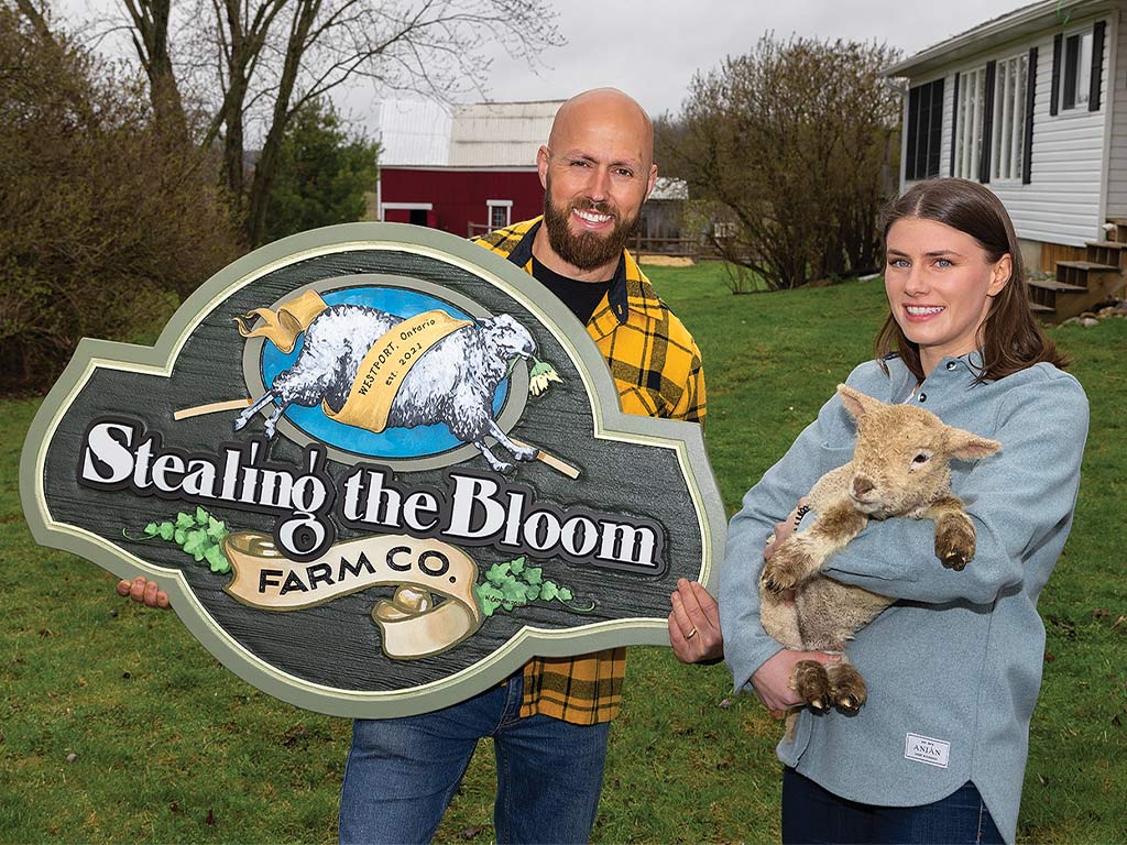 Heidi and Matthew Telfser holding their custom sign