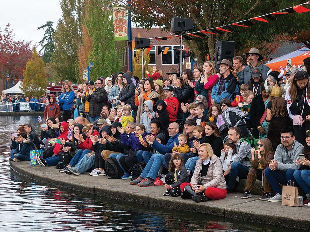 A packed crowd watching from shore