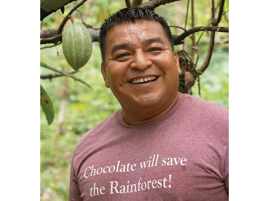 closeup of Juan Cho smiling in front of a tree