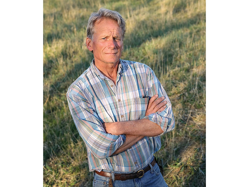 Ted Bannister standing with crossed arms in a field