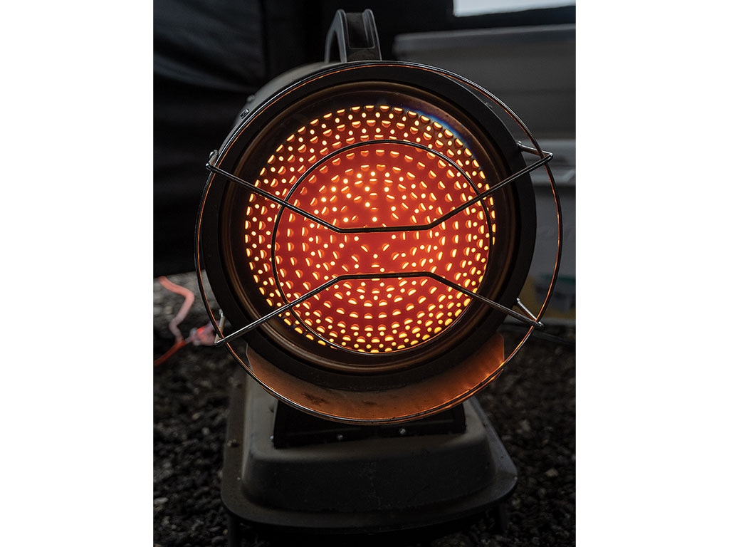 Portable electric heater glowing red, with protective grills.